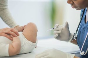 doctor injecting an injection on baby's lap - Autism