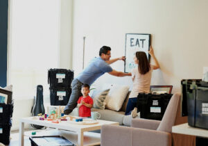 A family unpacking boxes in their new home, with a focus on organization and settling in. Autistic individuals - Autism Connect.