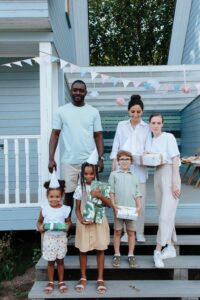 6)A family of four standing on home steps, smiling. - Autism Connect 
