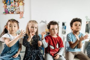 Children using hand gestures during a communication activity in a classroom setting.